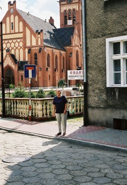 Luise vor dem Haus Schulstraße 2 mit Blick auf den Steinmezt und die kath. Kirchen in Heydebreck